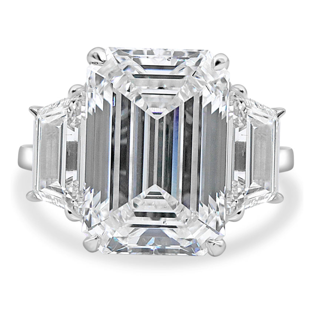 A three-stone emerald and trapezoid ring with a platinum band