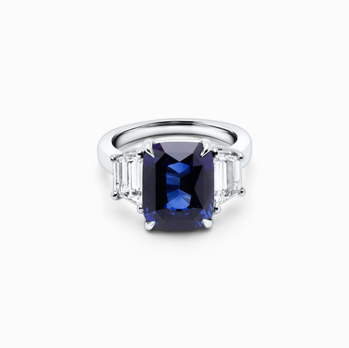 Three-stone sapphire and diamond engagement ring featuring a 7.71 carat sapphire and 1.23 carat E-F color diamond.
