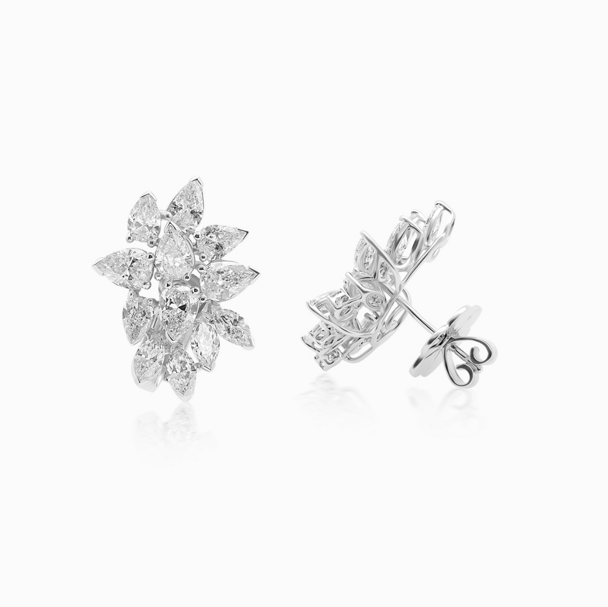 Platinum pear and marquise diamond cluster earrings with a sophisticated, dimensional design.