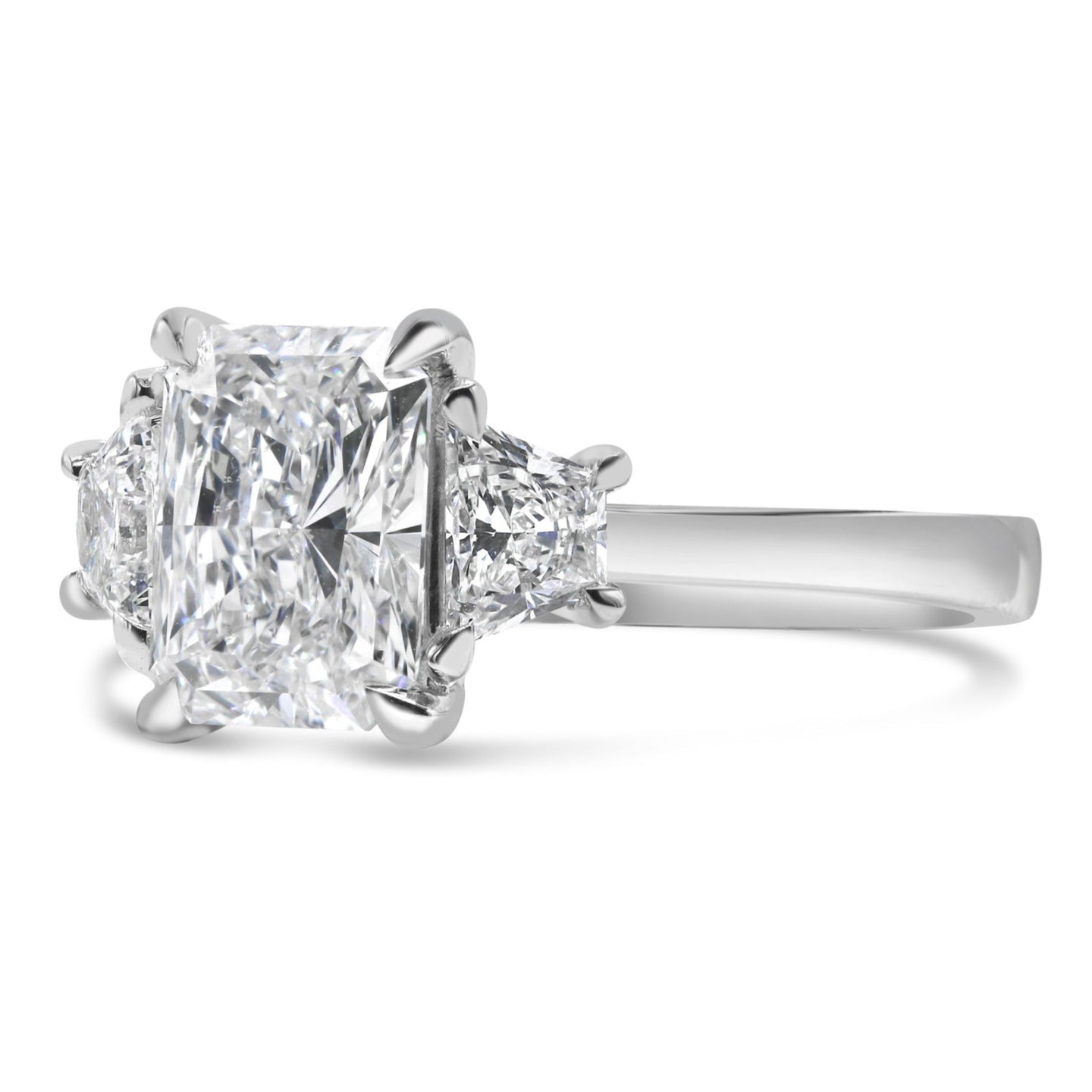 Radiant and trapezoid three stone diamond ring in 14K white gold featuring a lab grown radiant cut center diamond with trapezoid side stones.