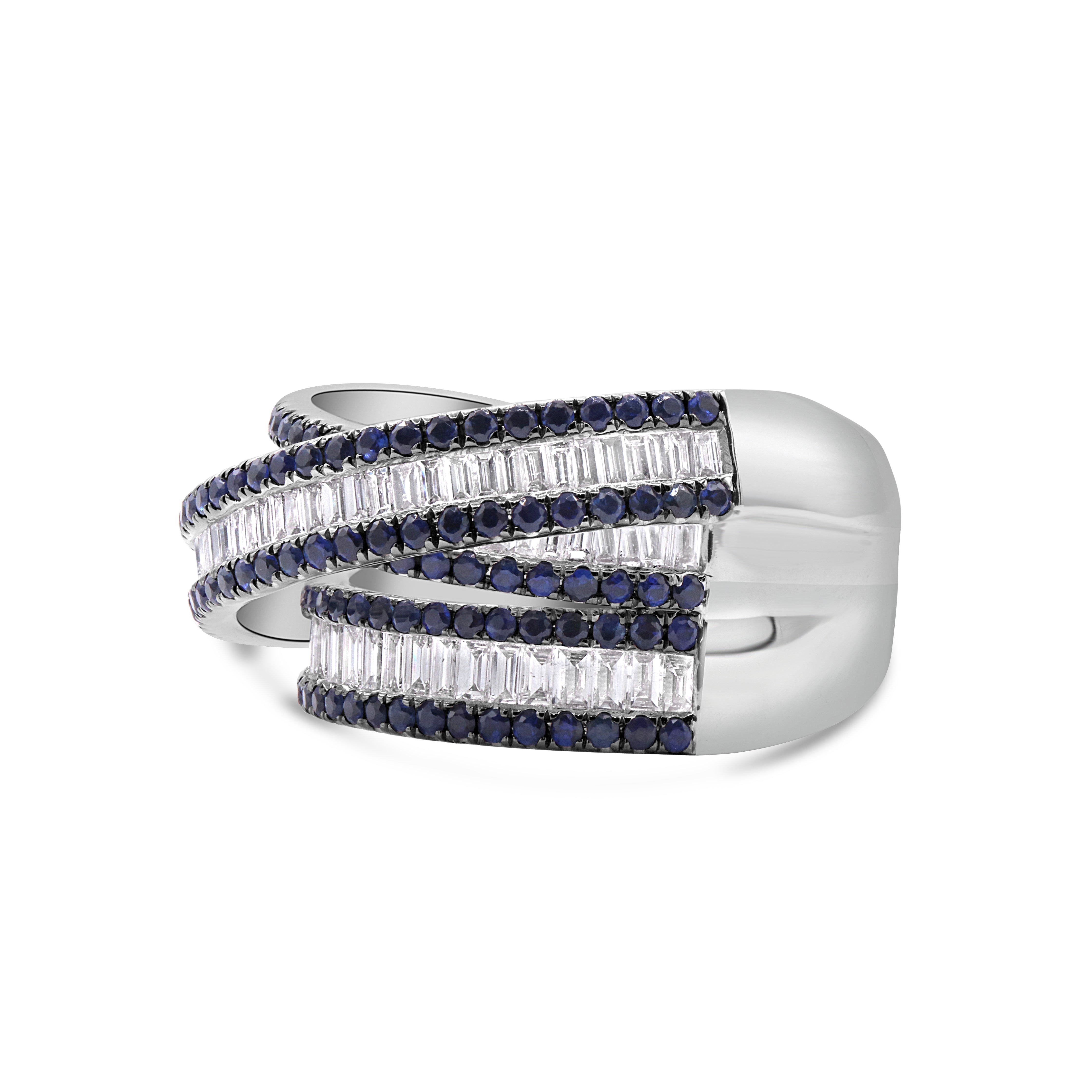 Sapphire and baguette diamond criss cross ring in 18K white gold featuring blue sapphires and baguette diamonds in a sculptural crossover design.