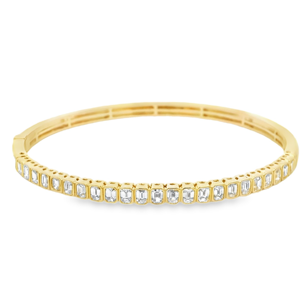 18K yellow and white gold bangle featuring approximately 2.50 carats of G-H color VS clarity emerald cut diamonds in a halfway setting.
