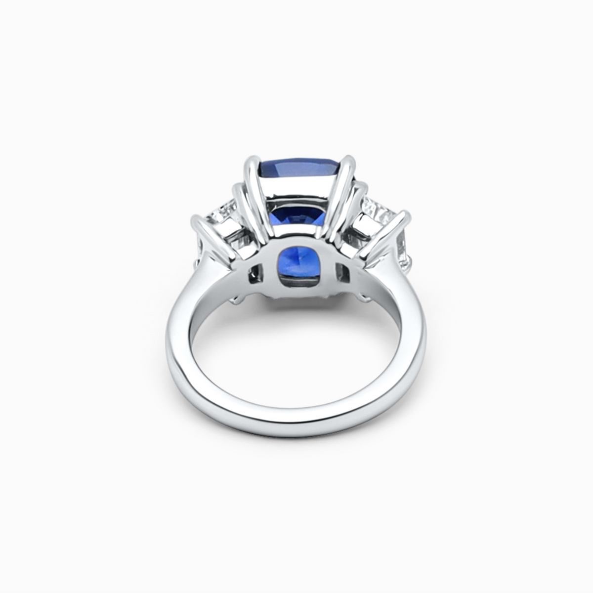 Luxury three-stone engagement ring featuring an excellent-cut 7.71 carat sapphire and E-F color diamond.