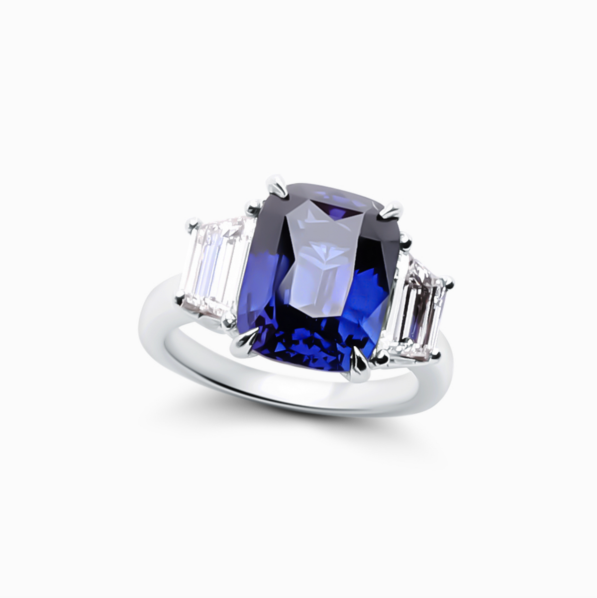 Radiant shape sapphire and diamond engagement ring featuring a 7.71 carat sapphire and a 1.23 carat E-F color diamond in a three-stone design.