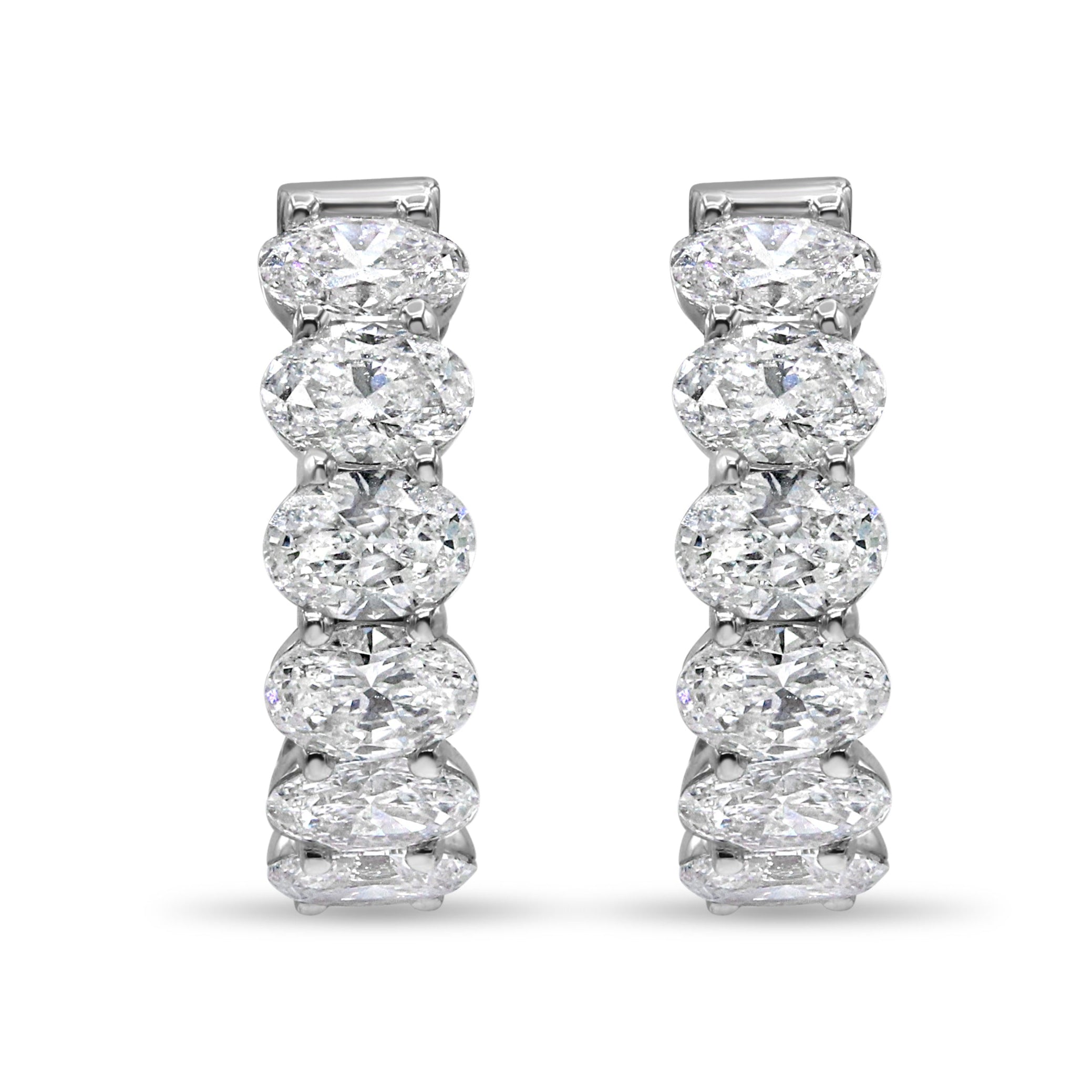 Lab grown mini oval cut diamond huggie earrings in 14K white gold featuring oval cut diamonds in a sleek, elegant design.