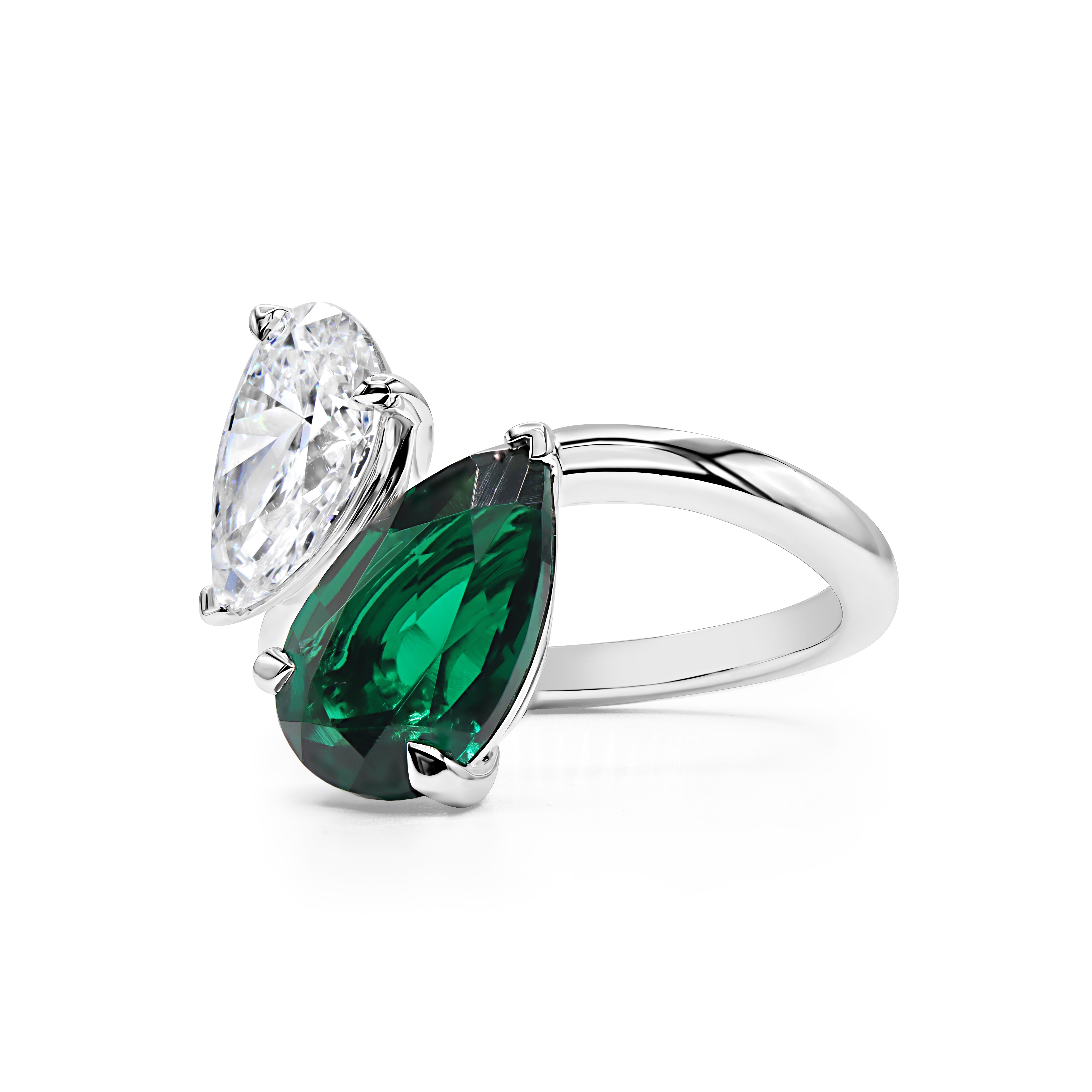 14K gold moi et toi ring featuring a lab grown pear shape diamond and green emerald in a modern two-stone design.